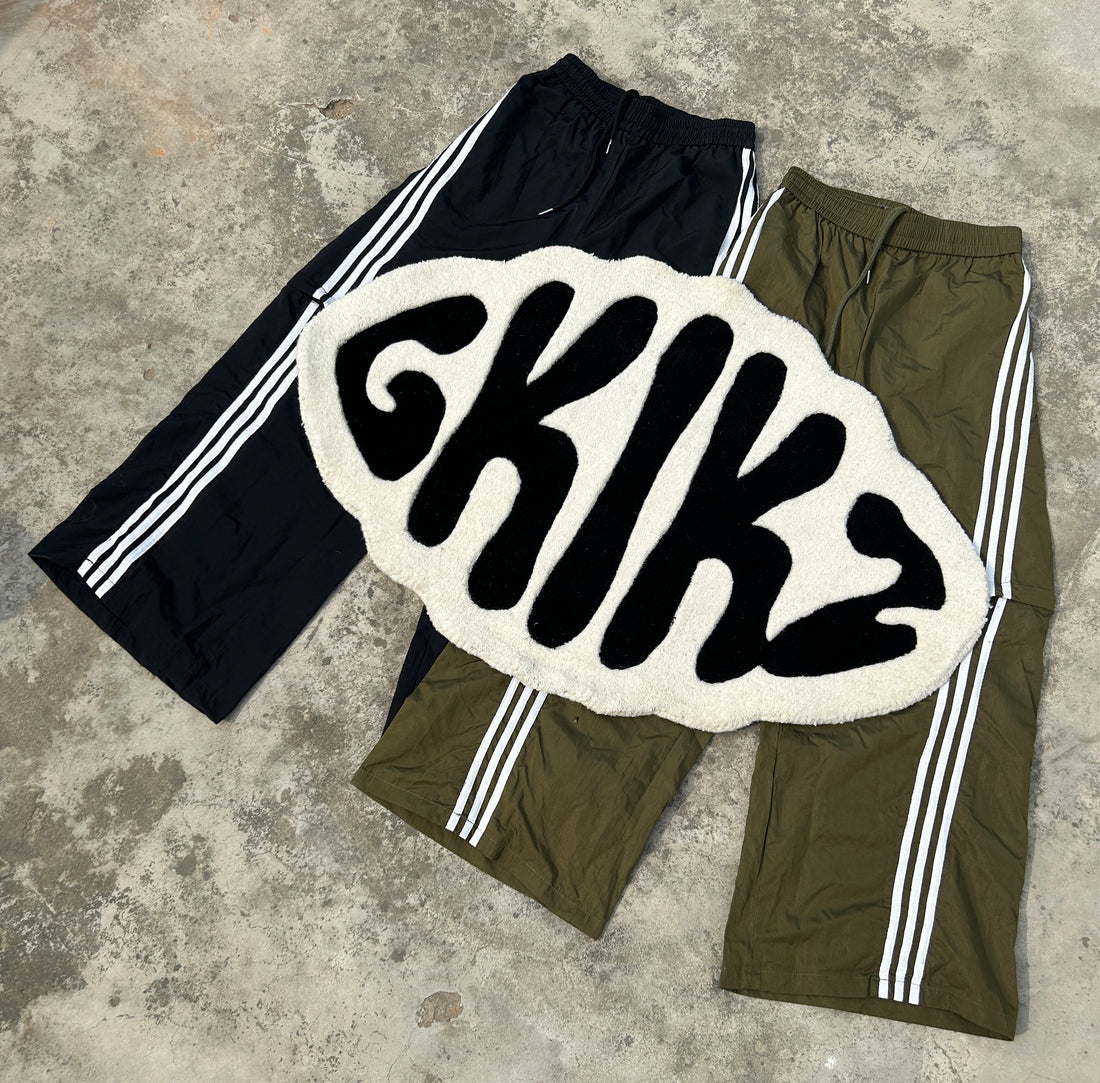 GKIKZ logo artwork displayed over black and olive trousers