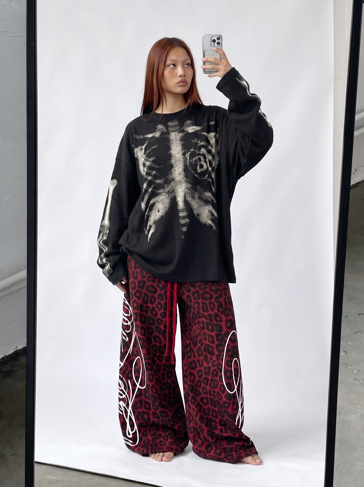 Black skeleton sweatshirt styled with red leopard wide-leg sweatpants